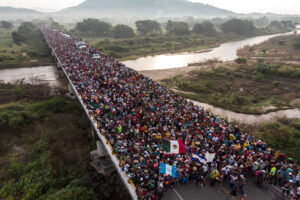 Aerial view of Honduran migrants heading in a caravan to the US, as the leave Arriaga on their way to San Pedro Tapanatepec, in southern Mexico on October 27, 2018. Mexico on Friday announced it will offer Central American migrants medical care, education for their children and access to temporary jobs as long as they stay in two southern states. / AFP PHOTO / Guillermo Arias