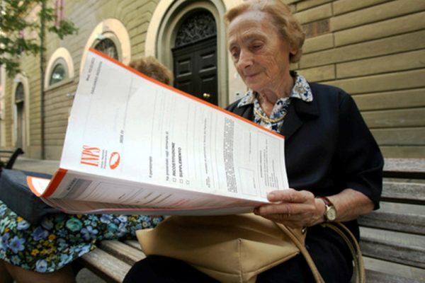 Una signora anziana legge una cartella dell'Inps a Pontedera in una foto d'archivio. ANSA / FRANCO SILVI