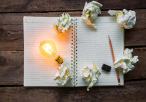 Note book and light bulb on wood table